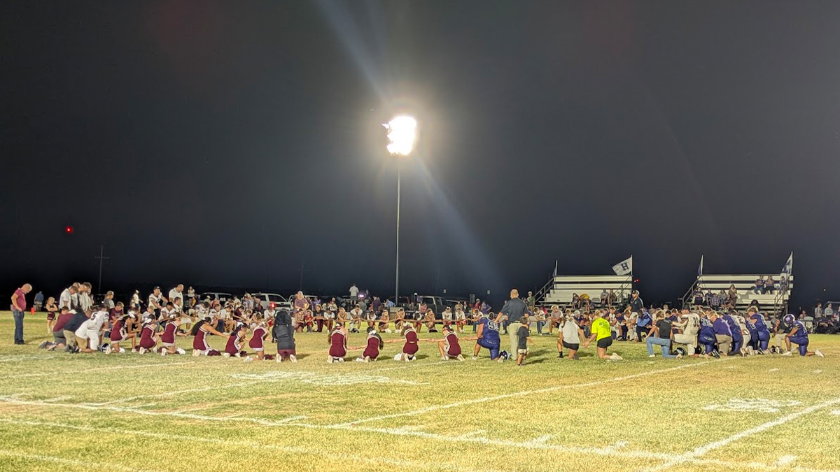Opposing teams in a postgame prayer circle